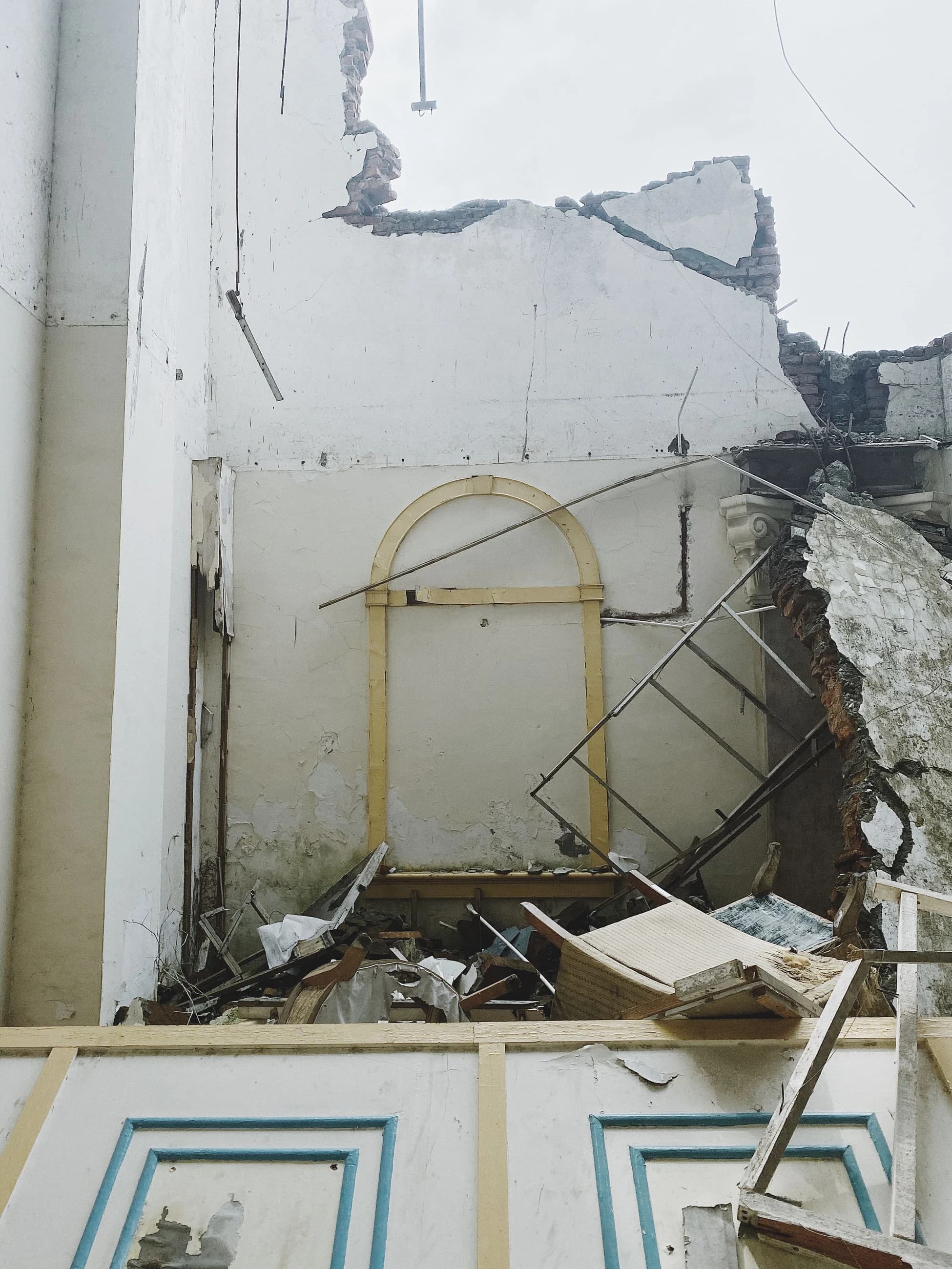 An exposed interior with partially removed walls and debris before rebuilding