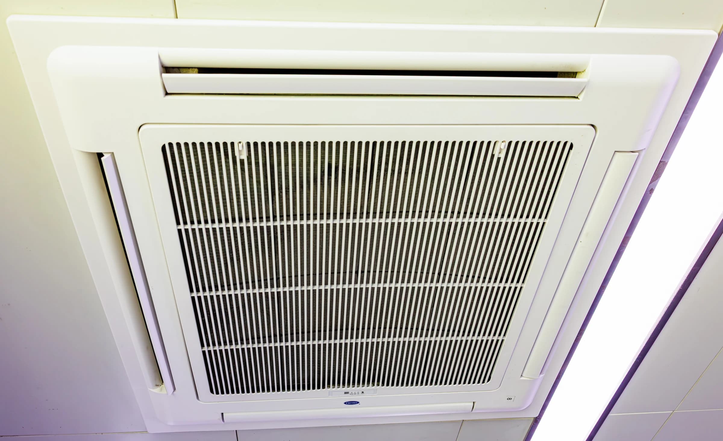 A ceiling cassette air-conditioning unit with a return-air grille and outlet louvers