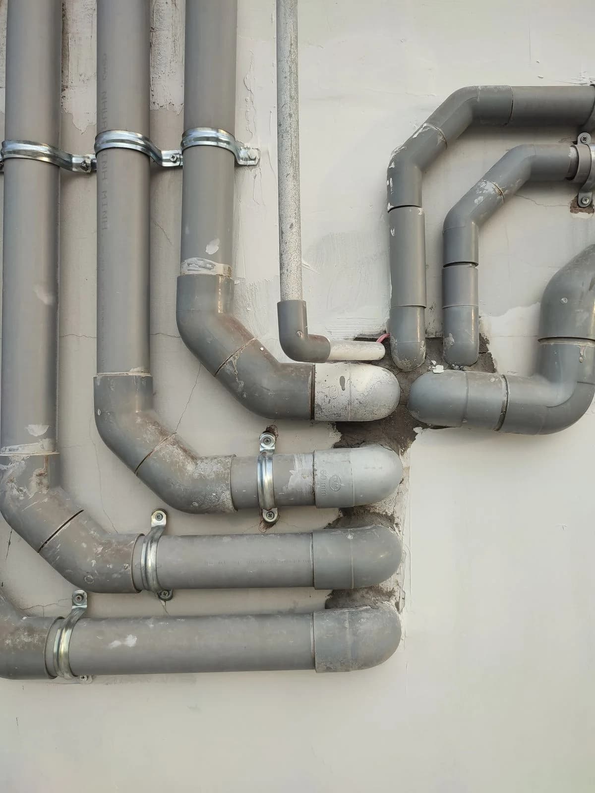 Wall-mounted drainage pipes with elbows and secured connections