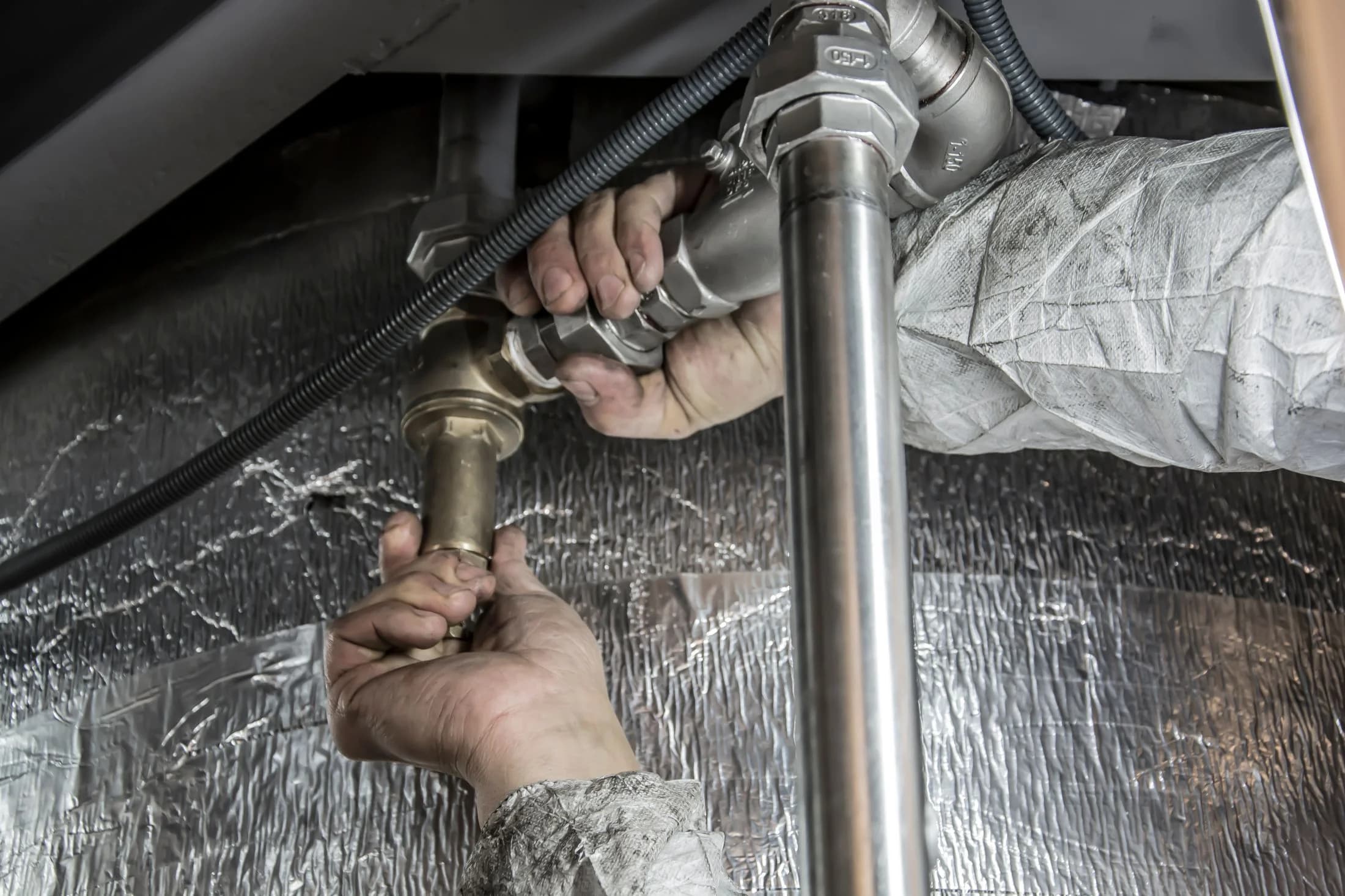 Plumber fitting a connection between steel plumbing pipes