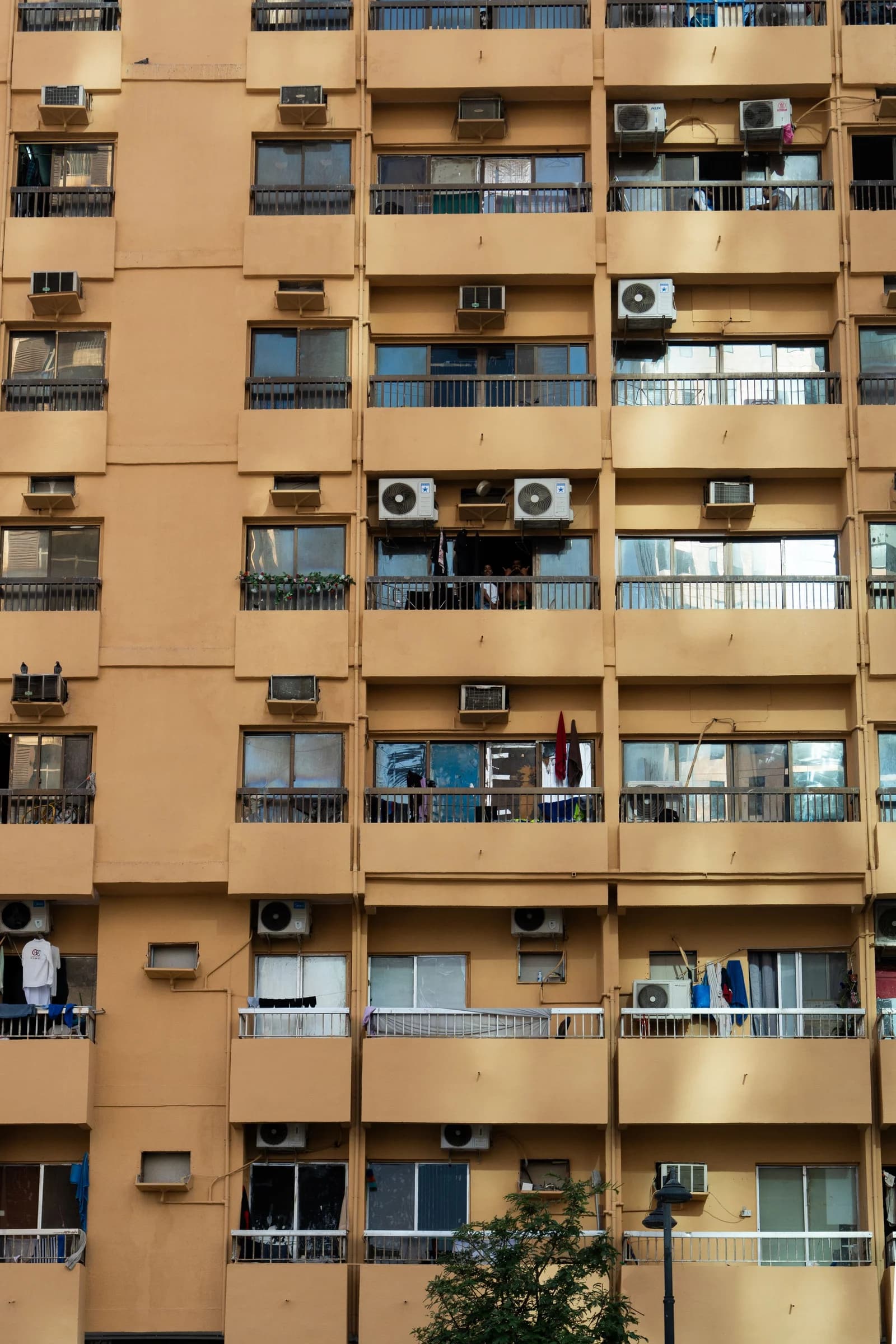 Outdoor air-conditioning units mounted beside apartment balconies in Abu Dhabi
