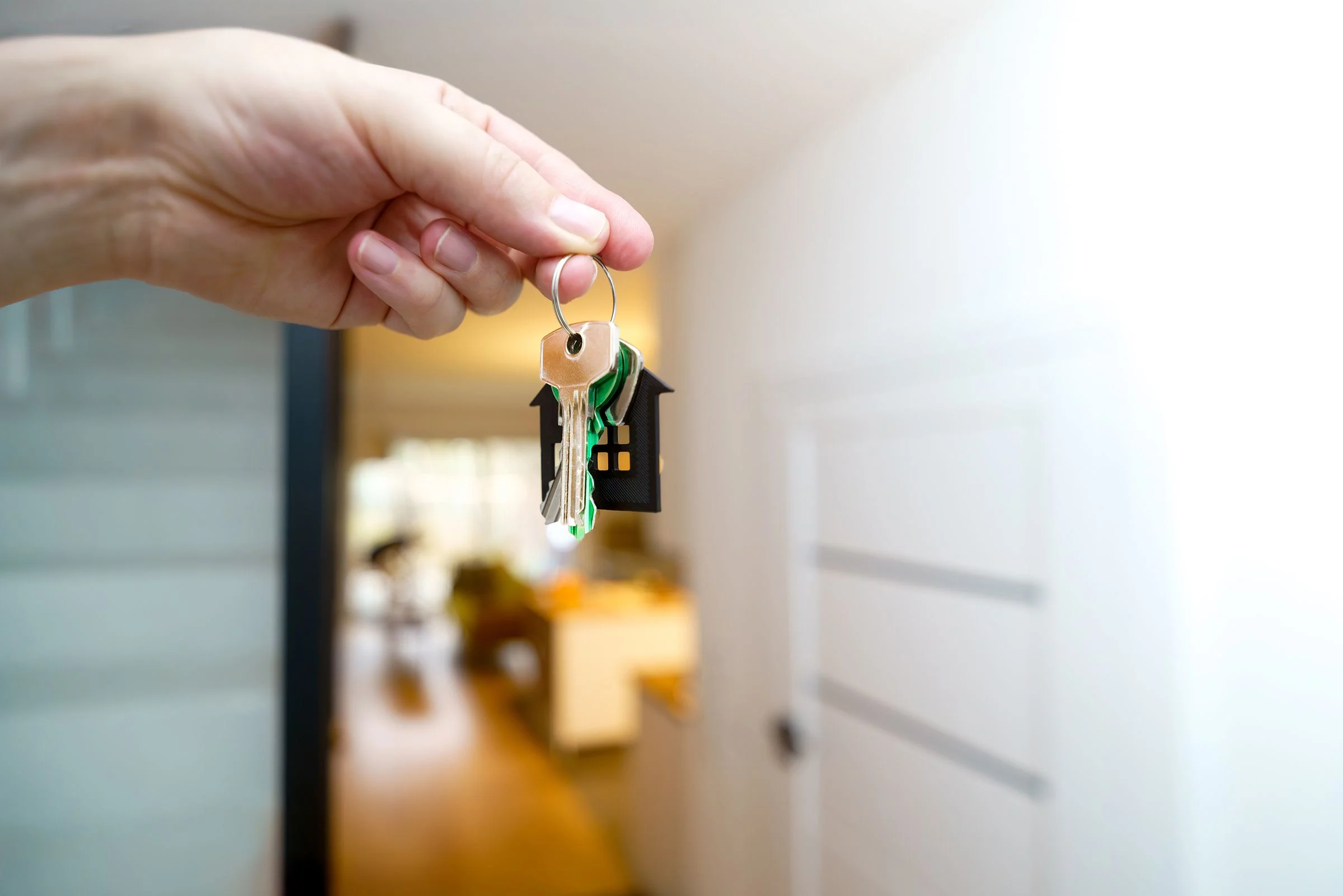 Apartment keys held in front of a bright modern interior