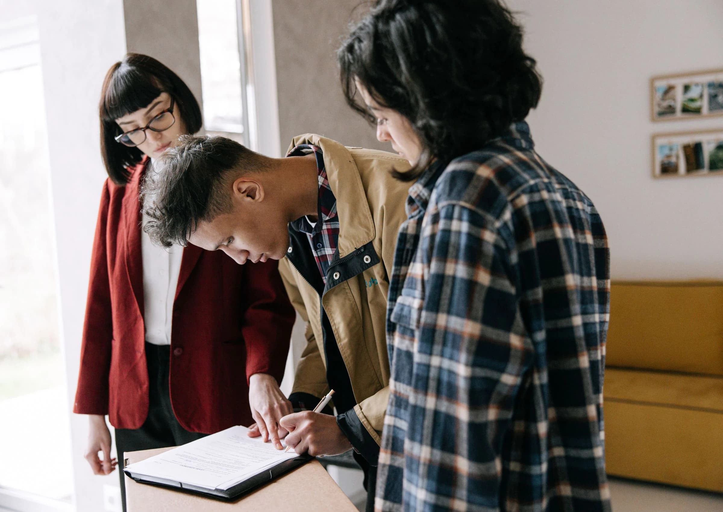 Couple signing property documents with a real estate advisor