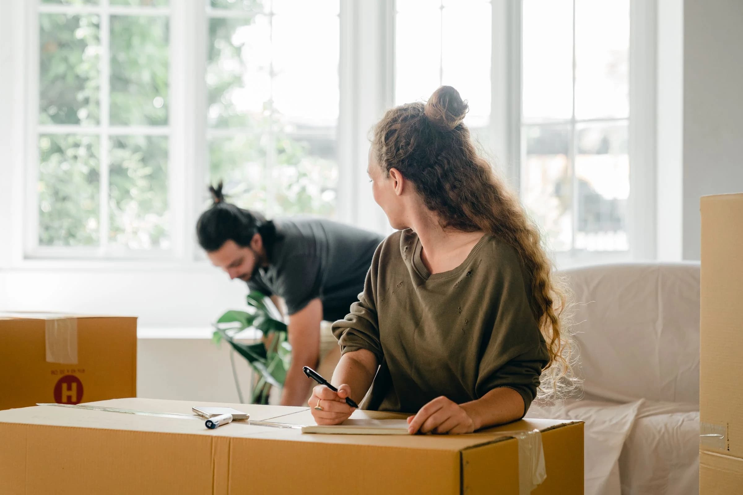 Residents preparing moving boxes and checking a packing list