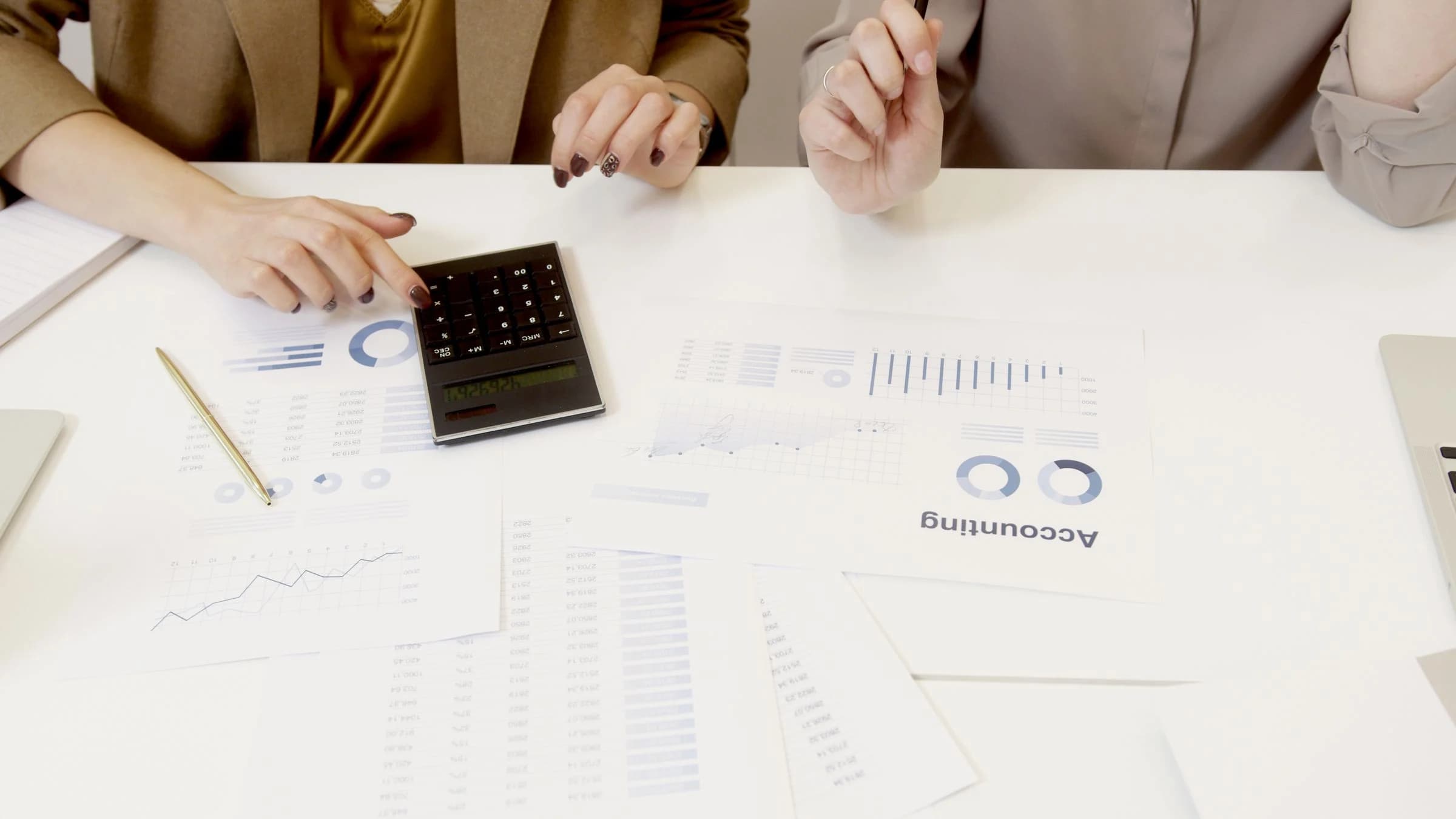 Two administrators reviewing accounting records and calculations