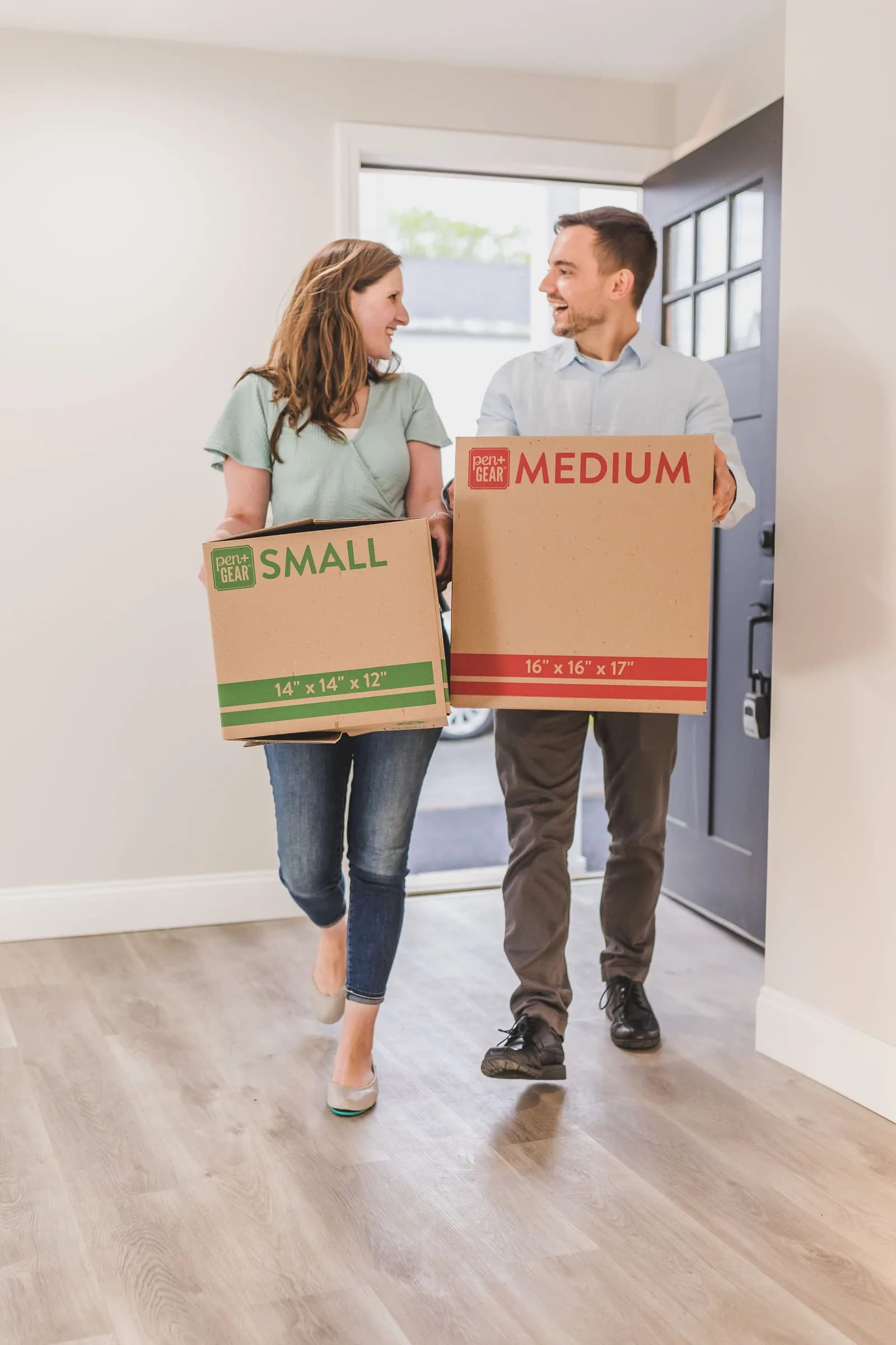 Residents carrying moving boxes into their apartment
