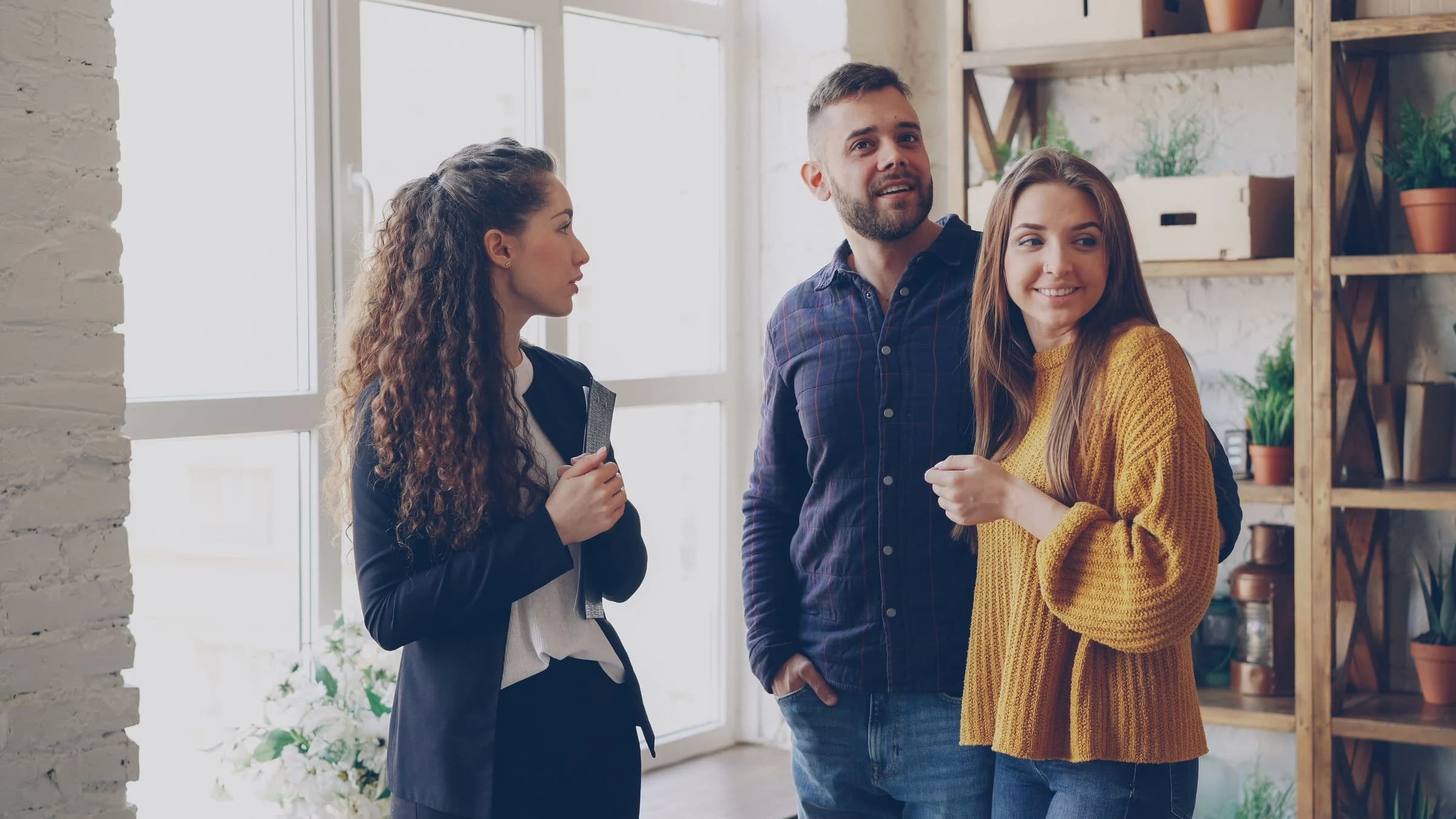 Property advisor discussing an apartment with a couple in a modern interior