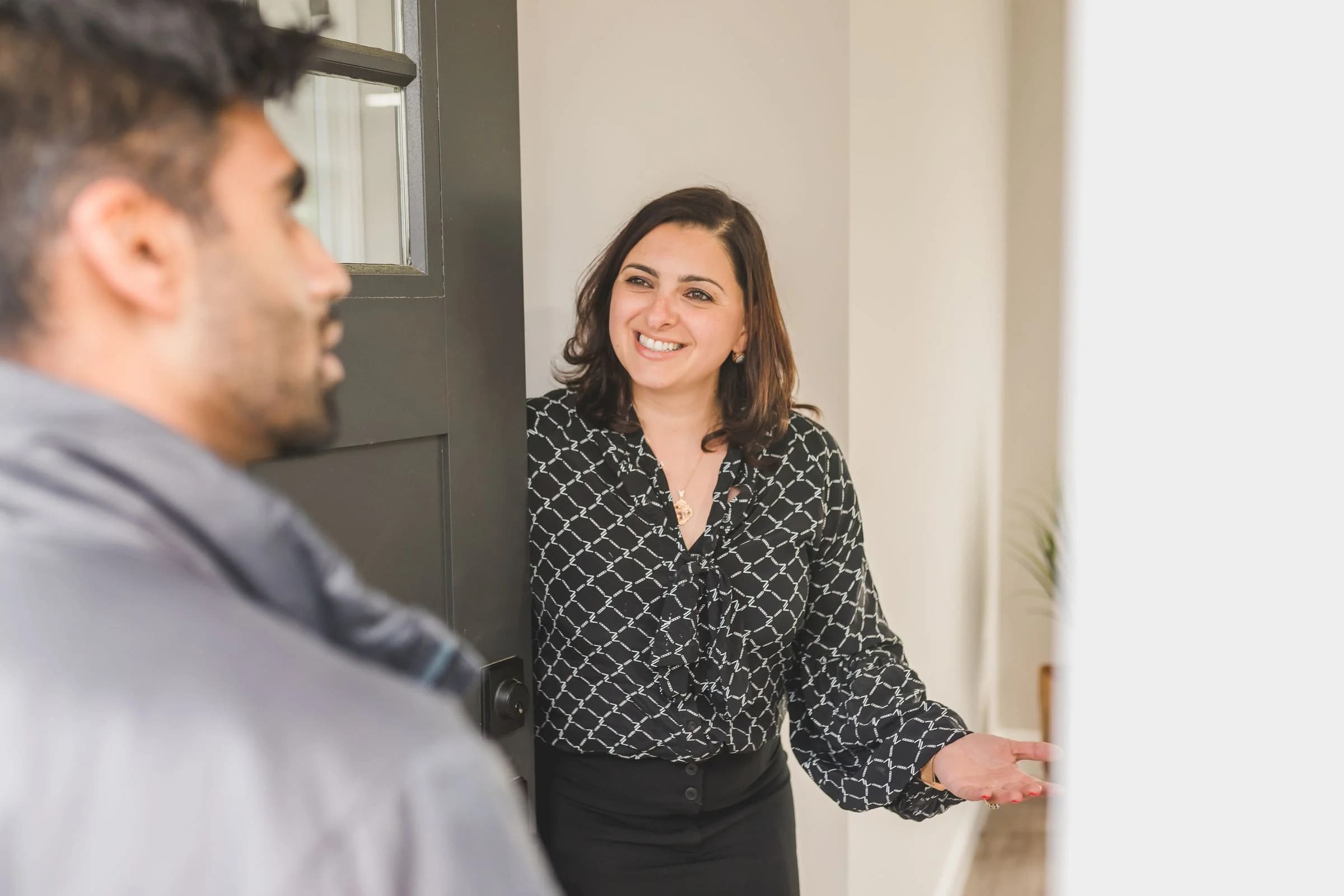 Property advisor welcoming a resident at an apartment entrance